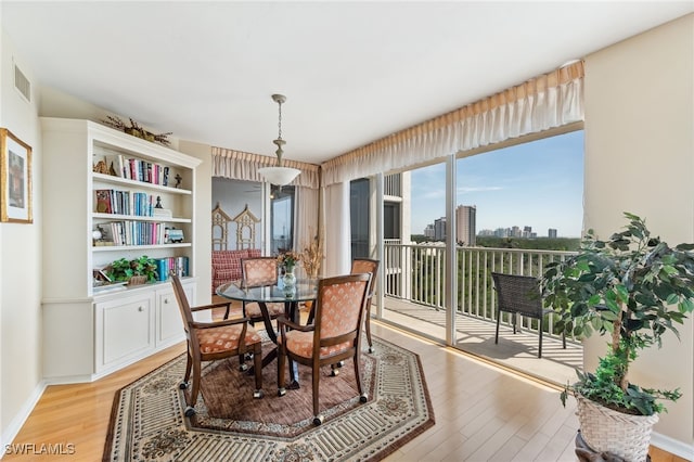6361 Pelican Bay Blvd Unit 605, Naples, FL 34108 - dining room with a view of city, visible vents, light wood-type flooring, and baseboards