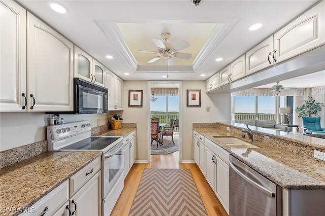 6361 Pelican Bay Blvd Unit 605, Naples, FL 34108 - kitchen with white electric range, stainless steel dishwasher, black microwave, a tray ceiling, and a ceiling fan