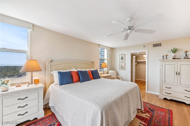 6361 Pelican Bay Blvd Unit 605, Naples, FL 34108 - bedroom with light wood-style floors, a ceiling fan, a spacious closet, visible vents, and baseboards
