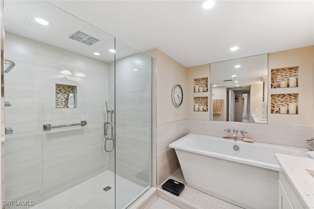 6361 Pelican Bay Blvd Unit 605, Naples, FL 34108 - bathroom featuring a shower stall, vanity, visible vents, recessed lighting, and tile walls