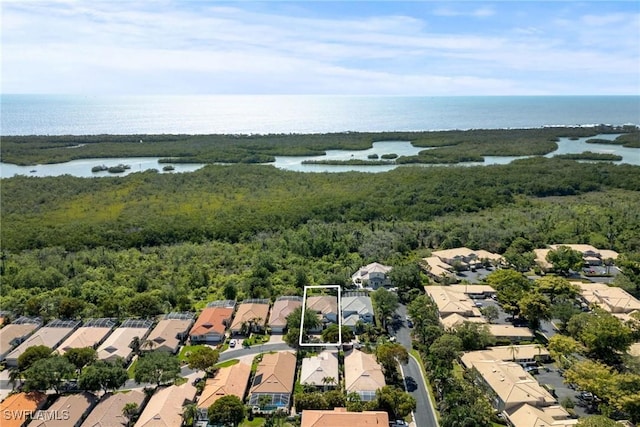 bird's eye view featuring a wooded view, a residential view, and a water view