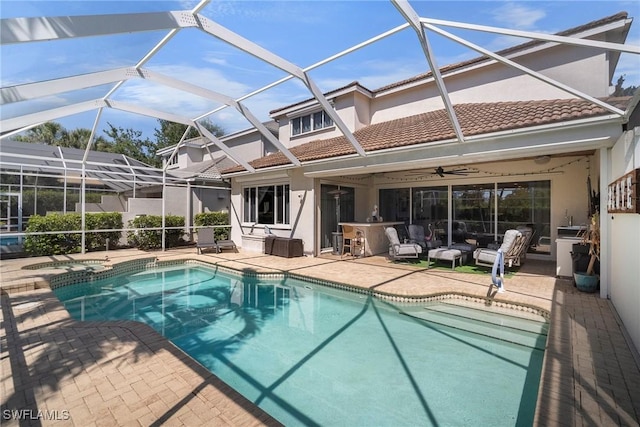 view of swimming pool featuring a patio area, a pool with connected hot tub, a lanai, and a ceiling fan