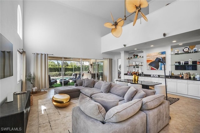 living room featuring a high ceiling, light tile patterned floors, and bar