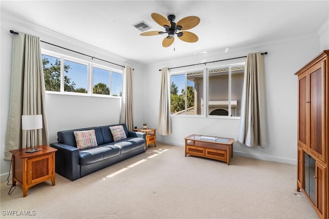 living area with light colored carpet, ceiling fan, visible vents, and plenty of natural light