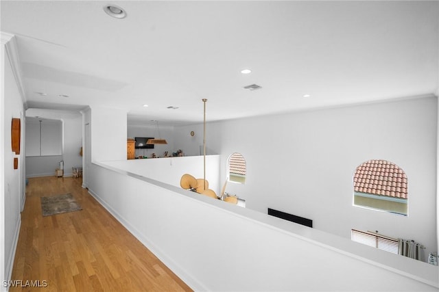 hall featuring light wood-style floors, a wealth of natural light, visible vents, and recessed lighting