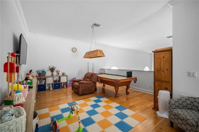 playroom featuring visible vents, crown molding, and wood finished floors