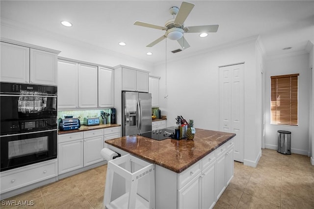 kitchen featuring ornamental molding, a ceiling fan, a kitchen island, visible vents, and black appliances