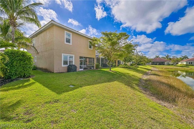 3544 Brittons Ct, Fort Myers, FL 33916 - back of house featuring a water view, a lawn, and stucco siding