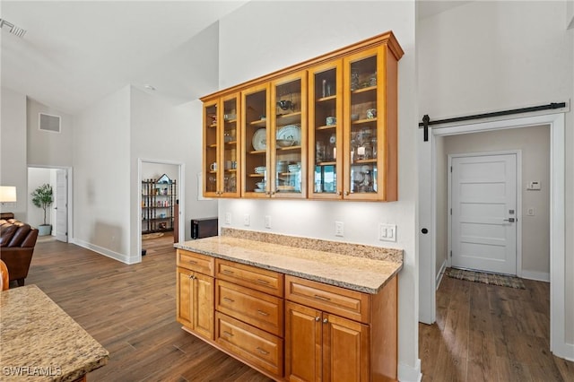 14190 Binghampton Dr, Fort Myers, FL 33905 - kitchen featuring dark wood finished floors, glass insert cabinets, open floor plan, high vaulted ceiling, and brown cabinetry
