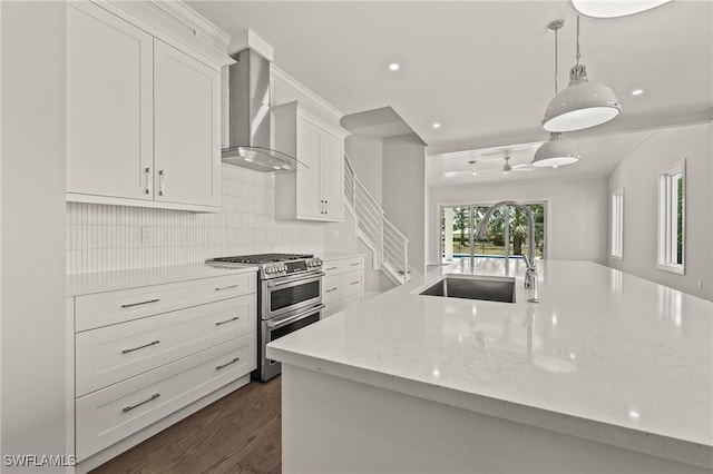 1136 Trail Terrace Dr, Naples, FL 34103 - kitchen with white cabinetry, a sink, range with two ovens, light stone counters, and wall chimney range hood