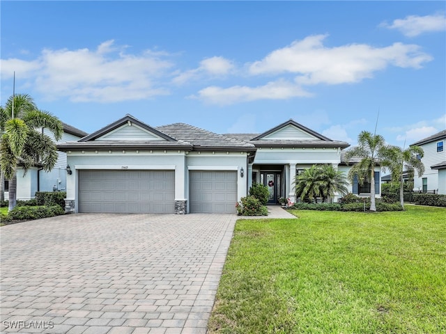 19469 The Place Blvd, Estero, FL 33928 - view of front of house with an attached garage, a front yard, decorative driveway, and stucco siding
