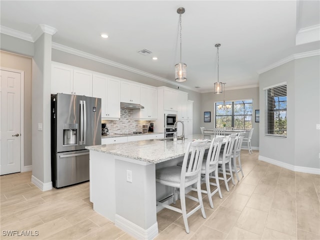 19469 The Place Blvd, Estero, FL 33928 - kitchen featuring stainless steel appliances, a large island, white cabinets, baseboards, and crown molding