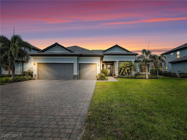 19469 The Place Blvd, Estero, FL 33928 - view of front of home featuring decorative driveway, a garage, a yard, and stucco siding