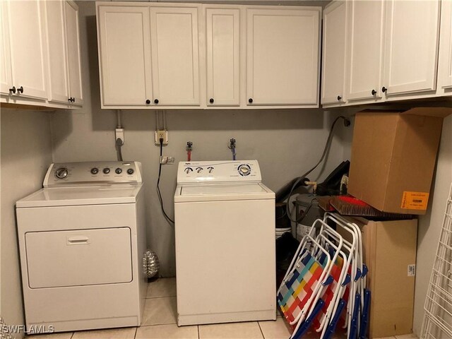 77 Cardinal Dr, North Fort Myers, FL 33917 - laundry area featuring cabinet space, washer and clothes dryer, and light tile patterned flooring