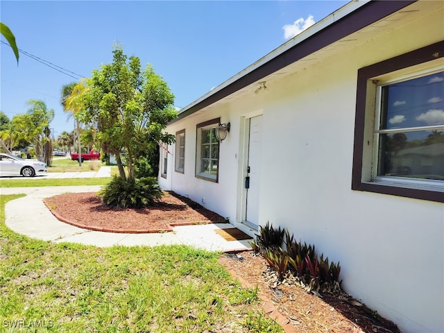 77 Cardinal Dr, North Fort Myers, FL 33917 - view of side of property featuring stucco siding