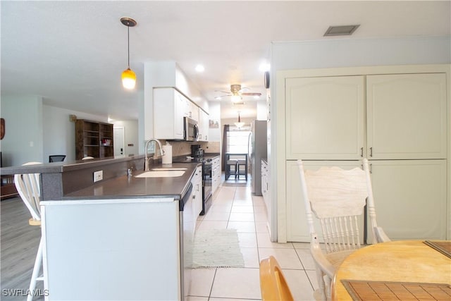 77 Cardinal Dr, North Fort Myers, FL 33917 - kitchen featuring a sink, stainless steel appliances, dark countertops, a ceiling fan, and pendant lighting