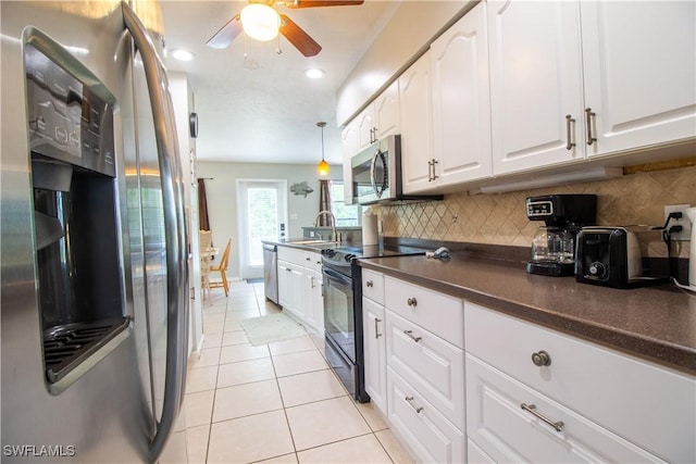77 Cardinal Dr, North Fort Myers, FL 33917 - kitchen featuring appliances with stainless steel finishes, dark countertops, ceiling fan, white cabinets, and a sink
