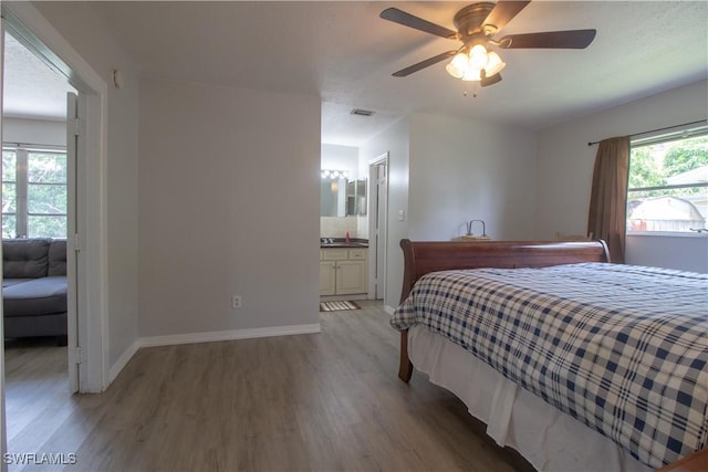 77 Cardinal Dr, North Fort Myers, FL 33917 - bedroom with light wood-type flooring, baseboards, connected bathroom, and ceiling fan