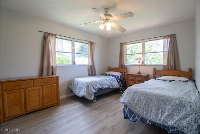 77 Cardinal Dr, North Fort Myers, FL 33917 - bedroom with multiple windows, light wood-style floors, ceiling fan, and baseboards