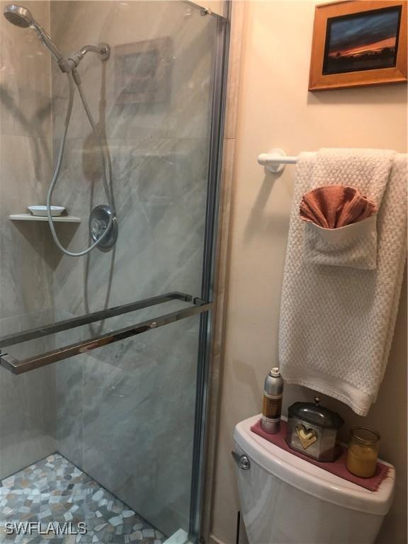 bathroom with a shower stall and toilet