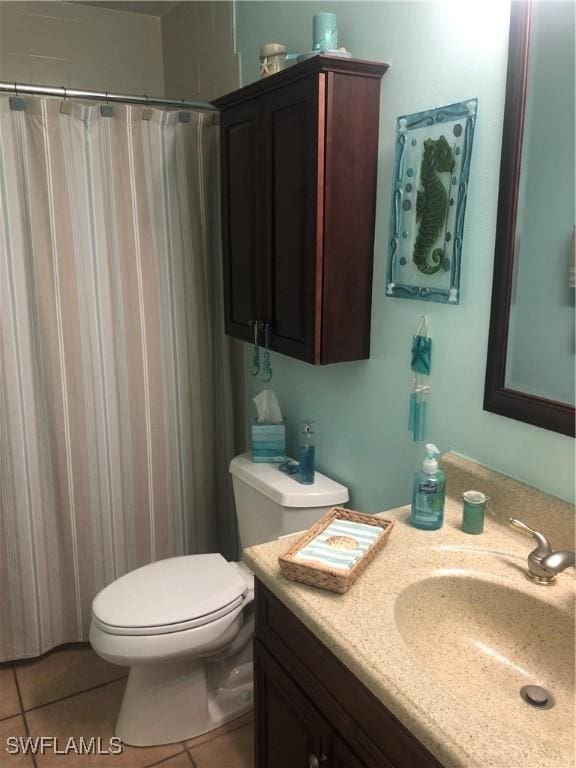full bathroom with a shower with curtain, vanity, tile patterned flooring, and toilet