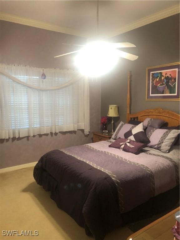 carpeted bedroom with ornamental molding