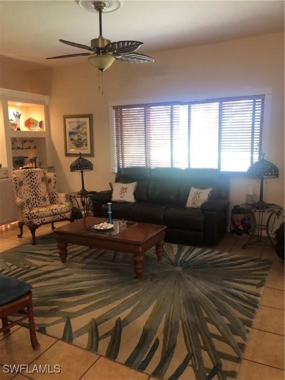 living area with light tile patterned flooring and a ceiling fan
