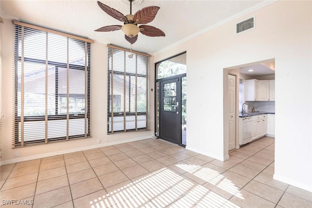 foyer with visible vents, a ceiling fan, light tile patterned floors, crown molding, and baseboards