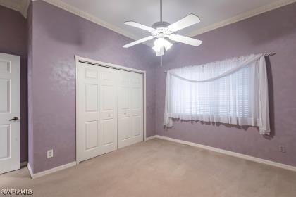 unfurnished bedroom with carpet flooring, baseboards, and ornamental molding