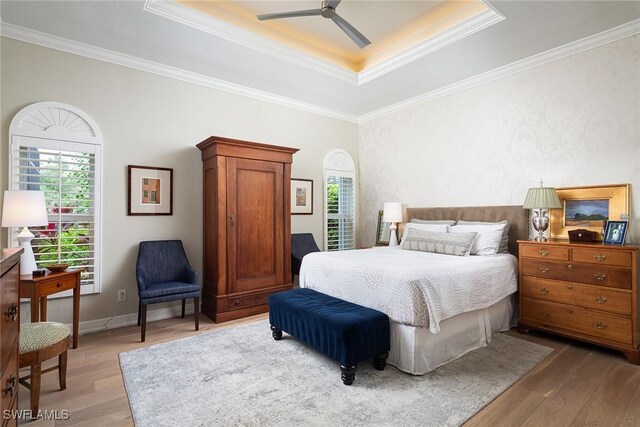 1002 Fountain Run, Naples, FL 34119 - bedroom featuring light wood-style floors, multiple windows, a tray ceiling, crown molding, and ceiling fan