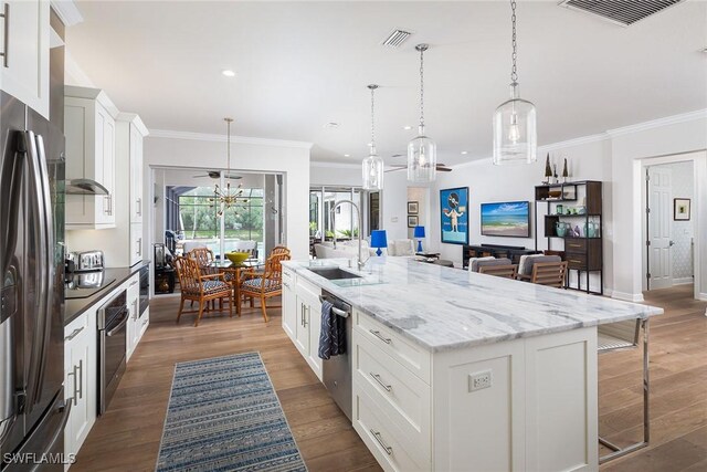 1002 Fountain Run, Naples, FL 34119 - kitchen featuring appliances with stainless steel finishes, a sink, an island with sink, a kitchen bar, and white cabinetry