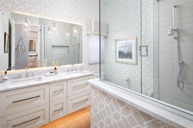 1002 Fountain Run, Naples, FL 34119 - bathroom with tiled shower, wood finished floors, and double vanity