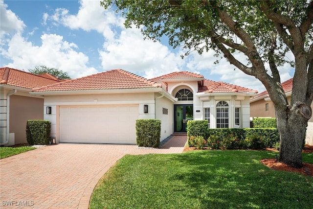 1002 Fountain Run, Naples, FL 34119 - mediterranean / spanish-style house featuring a garage, decorative driveway, a tile roof, a front lawn, and stucco siding