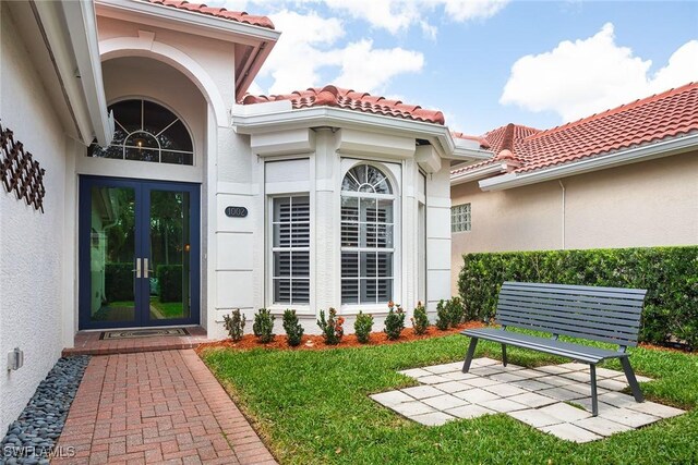 1002 Fountain Run, Naples, FL 34119 - doorway to property with french doors, stucco siding, a tiled roof, and a yard