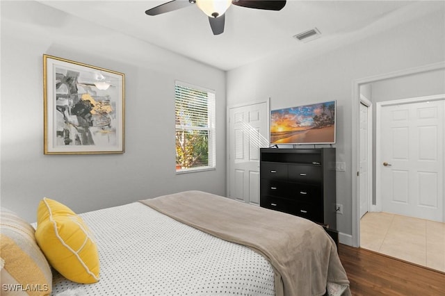 10021 Heather Ln Unit 803, Naples, FL 34119 - bedroom with wood finished floors, visible vents, and a ceiling fan