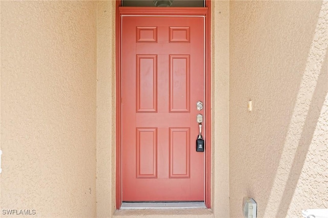property entrance featuring stucco siding