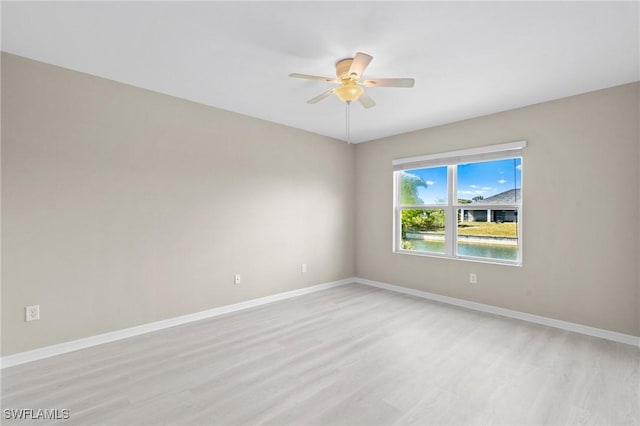 unfurnished room with baseboards, ceiling fan, and light wood-style flooring