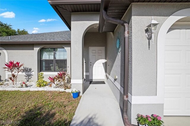4116 SW 15th Ave, Cape Coral, FL 33914 - property entrance featuring a garage, a shingled roof, and stucco siding