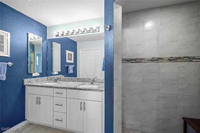 4116 SW 15th Ave, Cape Coral, FL 33914 - full bathroom with a textured wall, baseboards, a sink, and double vanity