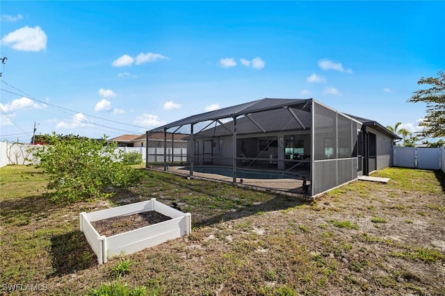 4116 SW 15th Ave, Cape Coral, FL 33914 - back of house featuring a lawn, a garden, fence, and a fenced in pool