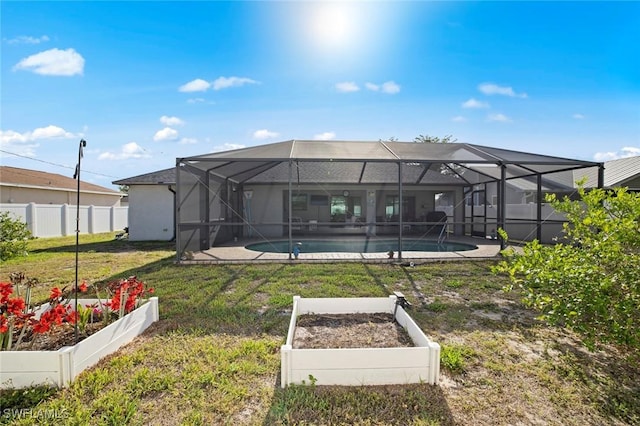 4116 SW 15th Ave, Cape Coral, FL 33914 - rear view of property featuring a lawn, a vegetable garden, an outdoor pool, and fence