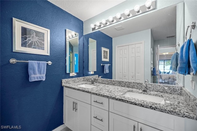 4116 SW 15th Ave, Cape Coral, FL 33914 - bathroom with a textured wall, a sink, and double vanity