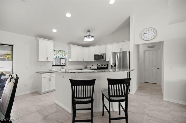 4116 SW 15th Ave, Cape Coral, FL 33914 - kitchen featuring a center island, appliances with stainless steel finishes, a breakfast bar, and white cabinetry