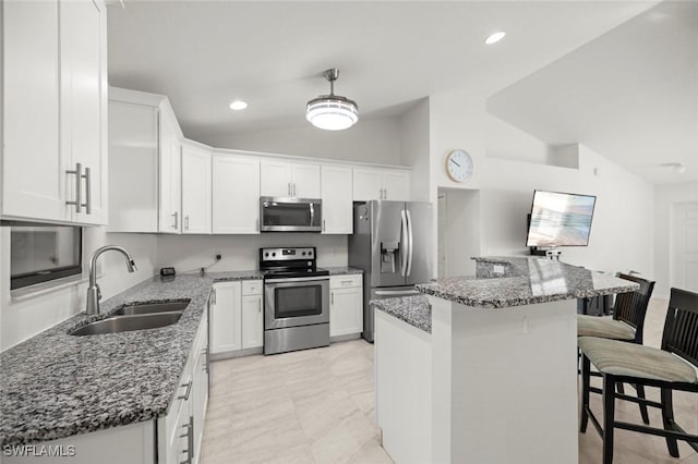 4116 SW 15th Ave, Cape Coral, FL 33914 - kitchen with a sink, dark stone counters, vaulted ceiling, appliances with stainless steel finishes, and a breakfast bar area