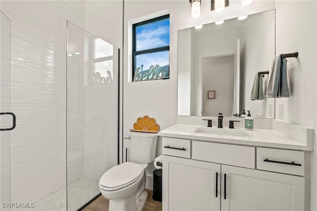 full bathroom with a shower stall, vanity, and toilet