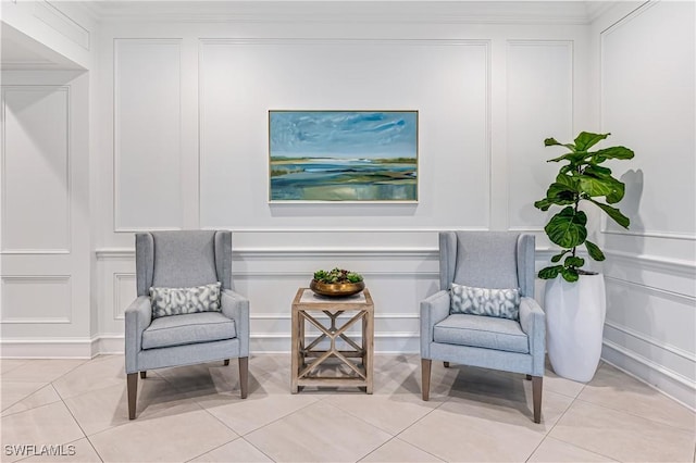 living area featuring a decorative wall and light tile patterned flooring