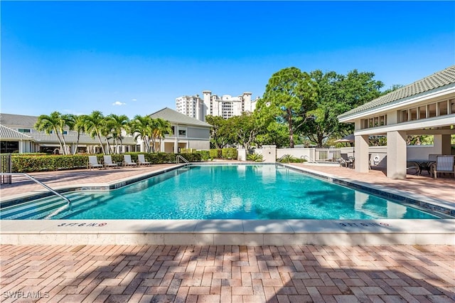 pool with a patio and fence