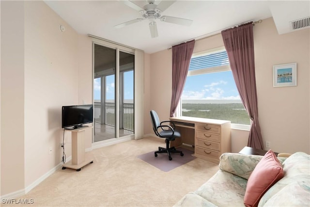 office space featuring a healthy amount of sunlight, visible vents, a ceiling fan, and carpet