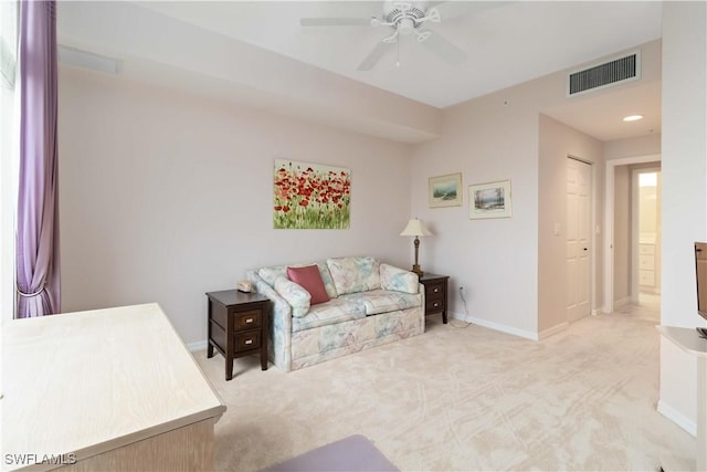 living area featuring visible vents, baseboards, a ceiling fan, and carpet