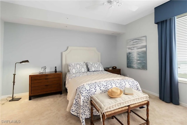 bedroom featuring light carpet, baseboards, and a ceiling fan